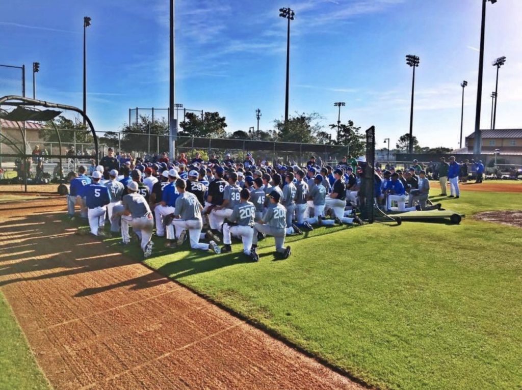 A group of baseball players sitting on the field